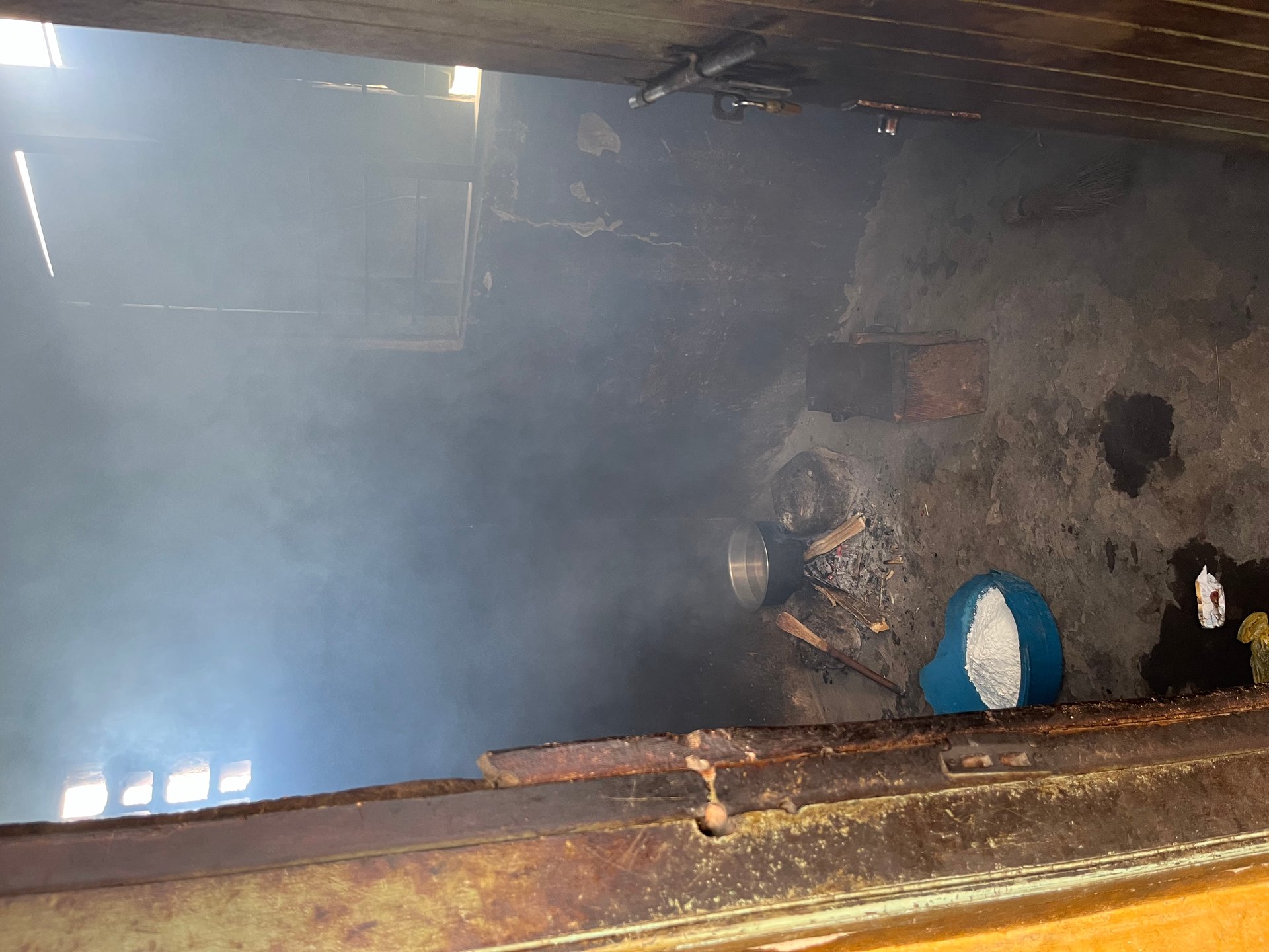 Smoke-filled school kitchen at Mount Elgon with pots over open fire and no ventilation