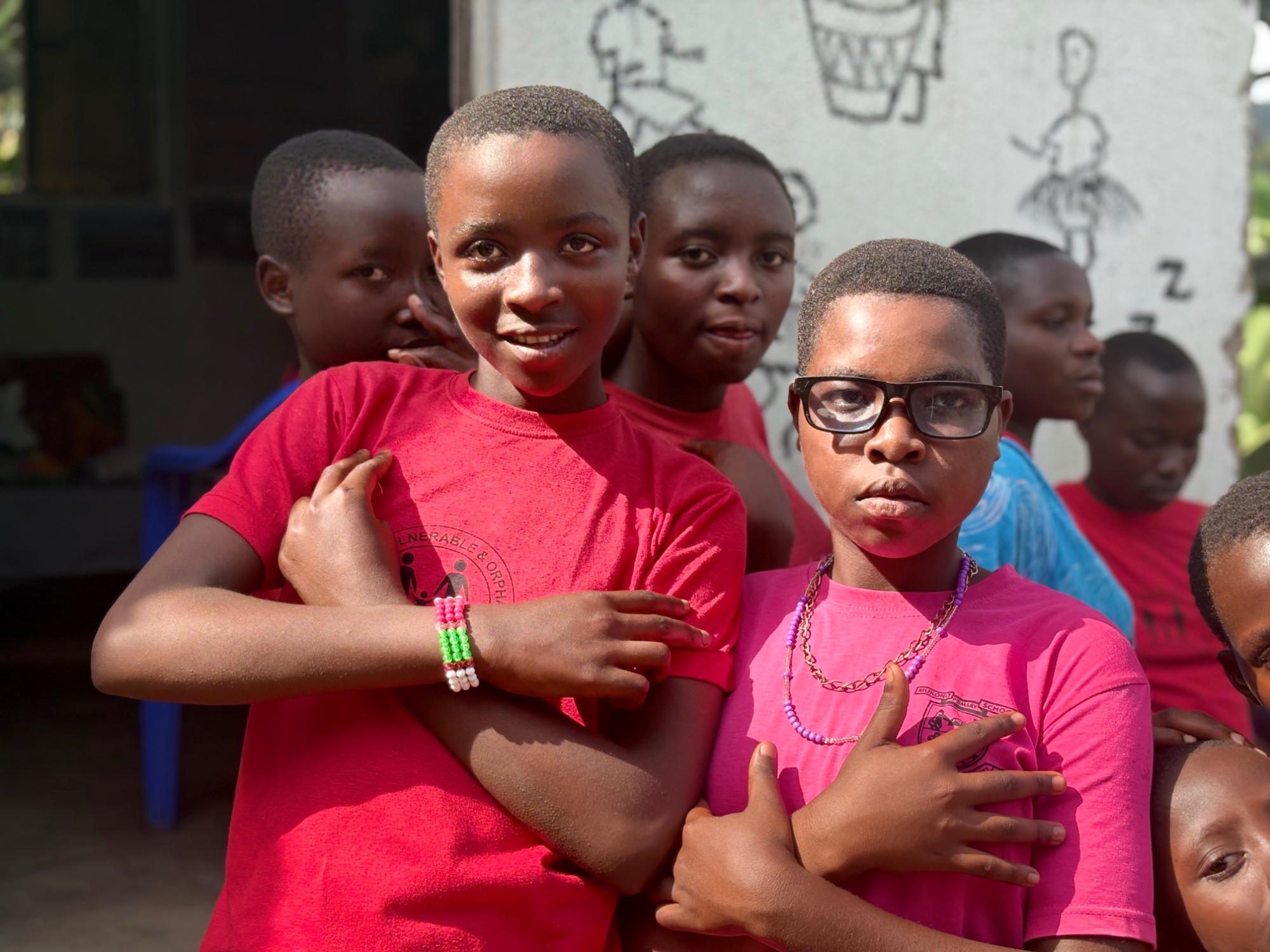Two teenagers posing confidently in front of the orphanage in Buhoma, Uganda