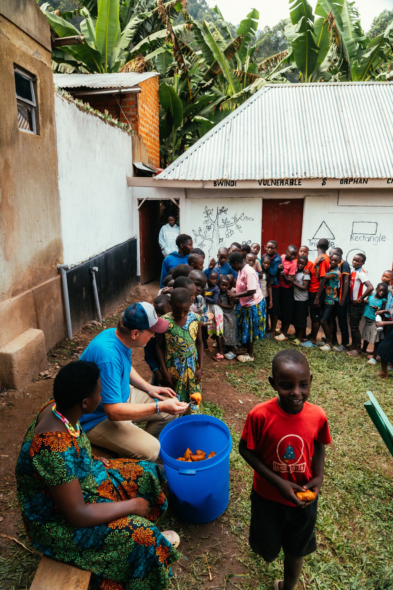 Mark handing out fruit to children