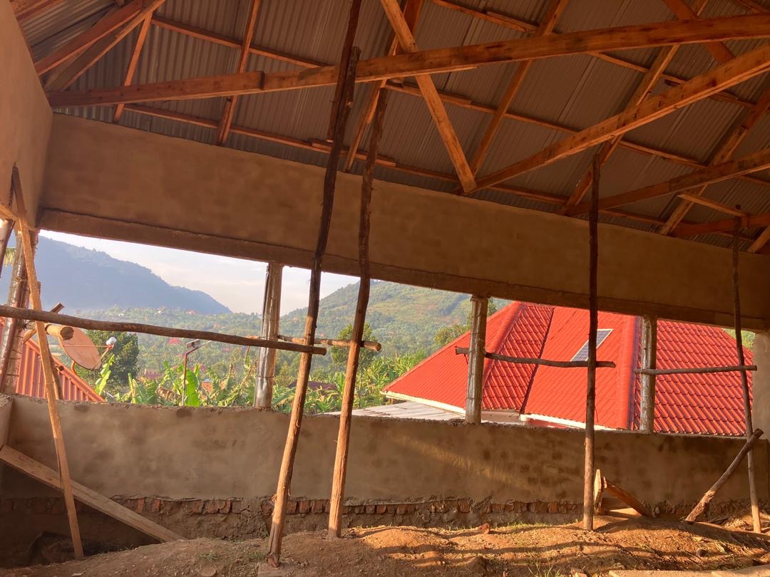 Interior of HopeKitchen under construction showing plastered walls, wooden roof beams and mountain view through windows